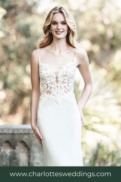 a woman in a wedding dress posing for the camera with her hands on her hips