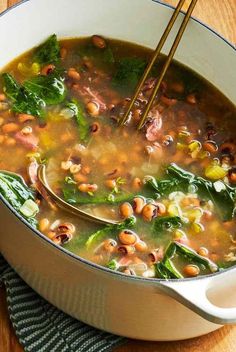 a bowl of soup with beans, spinach and other vegetables