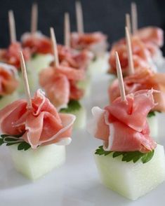 small appetizers with toothpicks are displayed on a plate