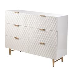 a white dresser with gold handles and drawers