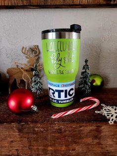 a cup that is sitting on a table next to christmas ornaments and candy canes