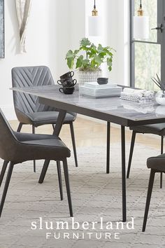 a dining room table with chairs and a plant in the center, surrounded by windows