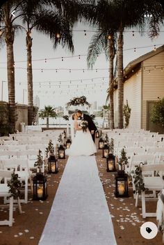 a bride and groom kissing at the end of their wedding ceremony in front of palm trees