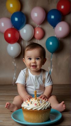 a baby sitting in front of a birthday cupcake