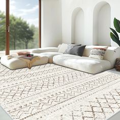 a large white couch sitting on top of a rug in a living room next to a potted plant