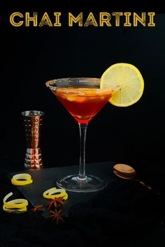 there is a cocktail in the glass with lemon wedges and cinnamon on the side