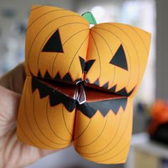 an origami pumpkin with two faces cut out