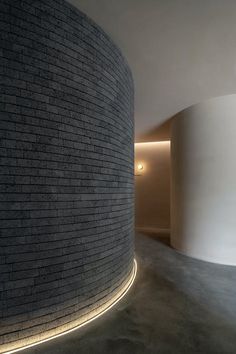 an empty room with a round brick wall