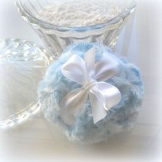 there is a blue and white ball with a bow on it next to a glass vase