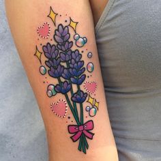 a woman with a tattoo on her arm has a bouquet of lavenders and bubbles