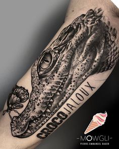 a black and white tattoo with an alligator on it's arm that says, crocodile louy