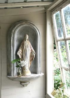 a statue is on the wall next to a window