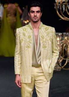 a man in a yellow suit standing on a runway