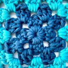 the crochet pattern is blue and has green leaves on it's center