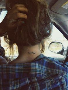 a woman with a tattoo on her neck sitting in a car