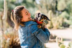 a woman holding a small dog in her arms