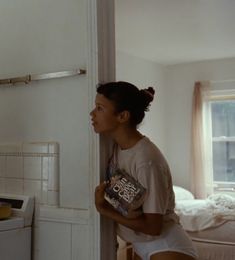 a woman standing next to a refrigerator in a kitchen