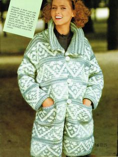 a woman in a green and white coat with a note attached to her jacket is smiling at the camera