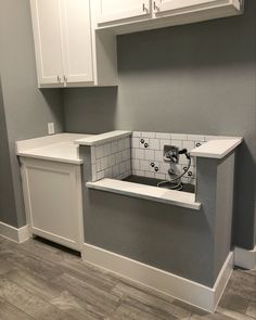 an empty kitchen with white cabinets and gray tile backsplash, in the process of remodeling