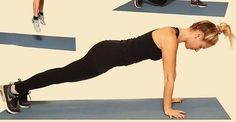 a woman doing push ups on a blue mat