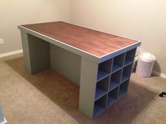 an empty room with a desk and bookshelf in the corner, next to a trash can