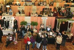 a group of people standing around tables with pictures on them