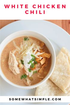 a bowl of chicken tortilla soup on a white plate with pita chips