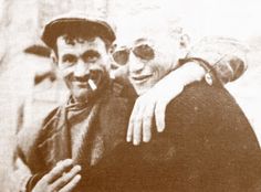 an old black and white photo of two men hugging each other with their arms around one another