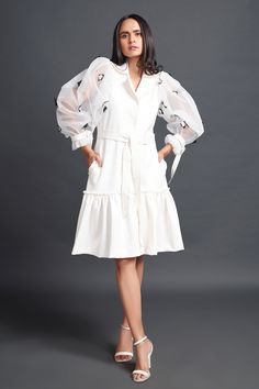 White dress, highlighted with floral confetti embroidery on puff sleeves.
Components: 1
Pattern: Placement Embroidery
Type Of Work: Floral Confetti
Neckline: Lapel Collar
Sleeve Type: Puff Sleeves
Fabric: Net
Color: White
Other Details: 
Side pockets
Frilled hem
Note: Belt worn by the model is not for sale
Occasion: Party - Aza Fashions Spring Organza Dress With Long Sleeves, Long Sleeve Organza Dresses For Spring, Spring Long Sleeve Organza Dresses, Elegant Lantern Sleeve Dress With Floral Embroidery, White Dresses With Ruffles And Lantern Sleeves, White Lantern Sleeve Dress With Ruffles, Spring Dresses With Blouson Lantern Sleeves, Elegant Organza Dress With Embroidered Sleeves, White Organza Dress With Puff Sleeves