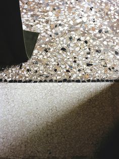 the floor is made up of pebbles and has a black object on it's side