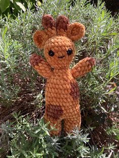 an orange stuffed animal sitting in some bushes