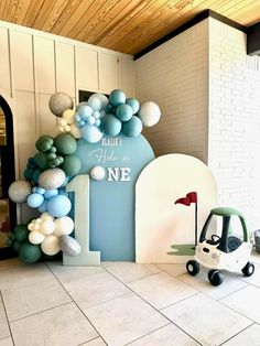 a balloon arch in the shape of a golf cart is decorated with blue and white balloons