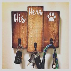 a couple of keys hanging from hooks on a wall next to two wooden signs with the words his and hers written on them