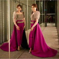 two women standing in front of a mirror with their hands on their hipss and one wearing a pink dress