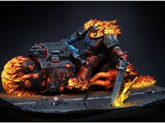 a man riding on the back of a motorcycle covered in flames