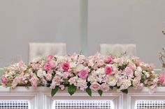 pink and white flowers are on the window sill