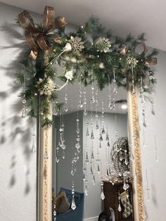 a mirror decorated with christmas decorations and hanging from it's sides in a room