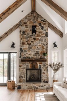 a living room with a stone fireplace and wooden floors