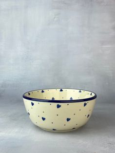 a blue and white bowl sitting on top of a gray table next to a wall