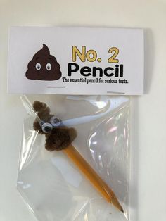 there is a pencil and some fake poop on top of the plastic wrapper