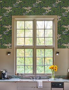 a kitchen with an open window, sink and dishwasher in front of it