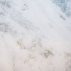 an airplane is flying in the sky with clouds and water around it, as seen from above