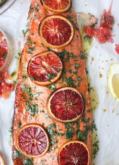 the salmon is covered with citrus and garnish