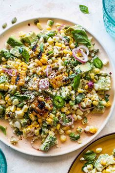 mexican corn salad on a plate with the words fiesta avocado corn salad above it