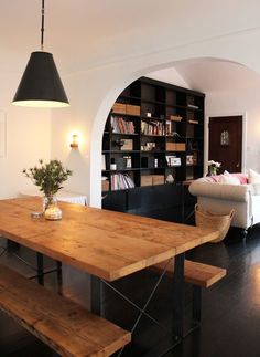 a wooden table sitting in front of a book shelf