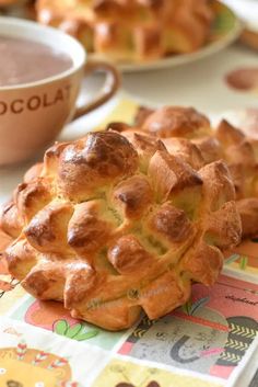 there is a pastry on the table next to a cup of hot chocolate and other food