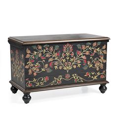 an ornately decorated chest on wheels with black paint and gold trimmings, sitting against a white background