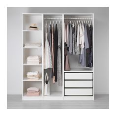 a white closet with clothes hanging on the shelves and other items in front of it