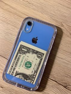 an iphone case with a dollar bill in it on a wooden surface, taken from above