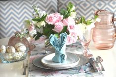 a table set for easter with pink and white flowers